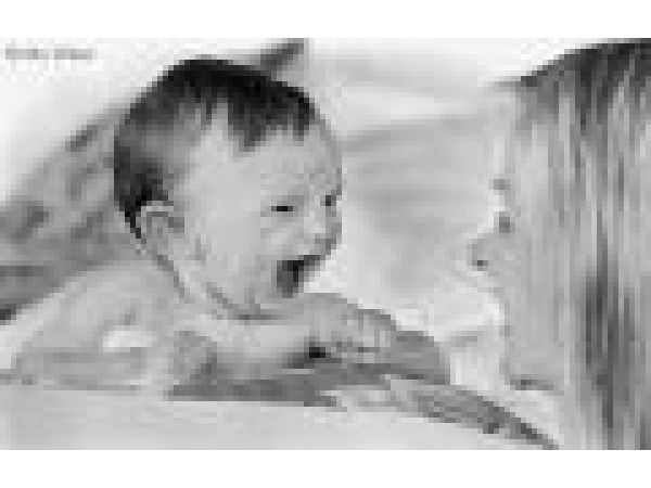 Baby showing excitement and laughing with mother.